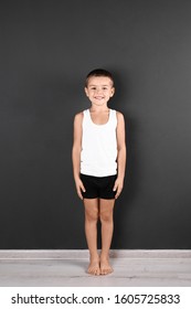 Cute Little Boy In Underwear Near Dark Wall