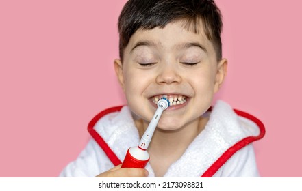 Cute Little Boy Using Electric Toothbrush For Daily Teeth Cleaning.pink Background,close Up,wide Banner.dental Care,dentist For Kids Concept. Smiling Boy, Diastema,space Between Teeth.