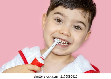 Cute Little Boy Using Electric Toothbrush For Daily Teeth Cleaning.pink Background,close Up,wide Banner.dental Care,dentist For Kids Concept. Smiling Boy, Diastema,space Between Teeth.