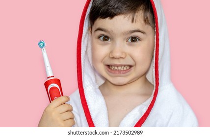 Cute Little Boy Using Electric Toothbrush For Daily Teeth Cleaning.pink Background,close Up,wide Banner.dental Care,dentist For Kids Concept. Smiling Boy, Diastema,space Between Teeth.