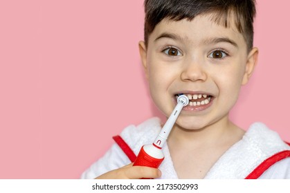 Cute Little Boy Using Electric Toothbrush For Daily Teeth Cleaning.pink Background,close Up,wide Banner.dental Care,dentist For Kids Concept. Smiling Boy, Diastema,space Between Teeth.