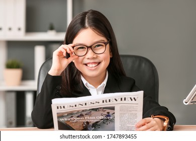 Cute Little Businesswoman With Newspaper In Office