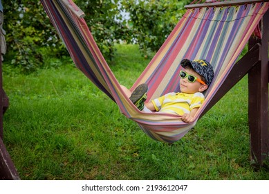 Cute Little Caucasian Boy Relaxing And Having Fun In Multicolored Hammock In Backyard Or Outdoor Playground. Summer Active Leisure For Kids. Child Swinging On Hammock. Activities For Children.