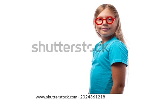 Cute little Caucasian girl in a blue T-shirt and round red glasses on a white background, place for text. Education concept.