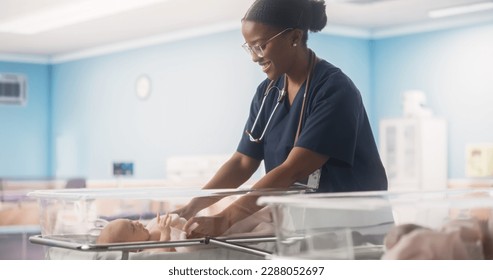 Cute Little Caucasian Newborn Baby Lying in Bassinet in a Maternity Hospital. Beautiful Black Pediatrician Covering Child with Blanket. Healthcare, Pregnancy and Motherhood Concept