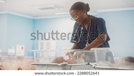 Cute Little Caucasian Newborn Baby Lying in Bassinet in a Maternity Hospital. Beautiful Black Pediatrician Checking Up on a Child. Healthcare, Pregnancy and Motherhood Concept