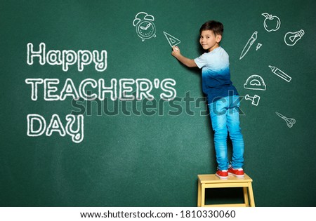 Cute little child drawing ruler near phrase Happy Teacher's Day on chalkboard