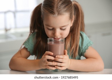 Cute Little Child Drinking Tasty Chocolate Milk In Kitchen, Closeup