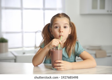 Cute Little Child Drinking Tasty Chocolate Milk In Kitchen