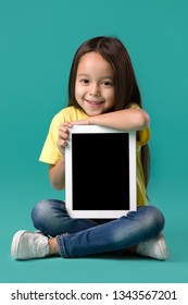 Cute Little Child Girl Holding Blank Tablet Computer On Blue Background