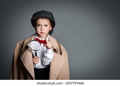 Cute Little Child In Hat With Magnifying Glass Playing Detective On Grey Background, Space For Text