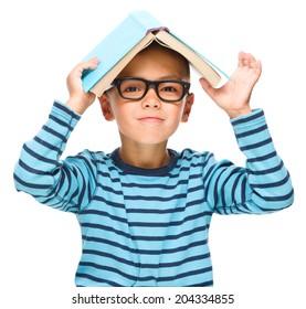 Cute little child plays with book while wearing glasses, isolated over white