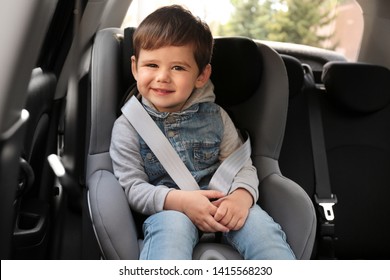 Cute Little Child Sitting In Safety Seat Inside Car. Danger Prevention