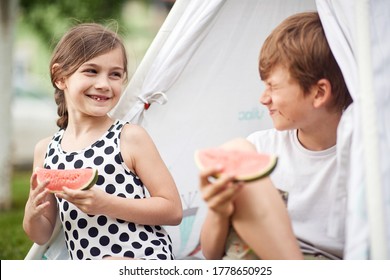 Cute  Little Children At Backyard In Teepee And Eats Watermelon.