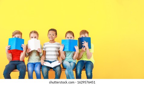 Cute little children with books on color background - Shutterstock ID 1629576451