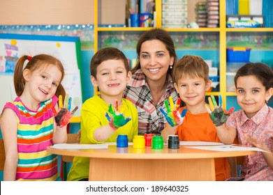 Cute little children drawing with teacher at preschool class