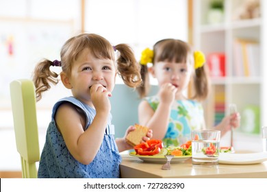 Kleine süße Kinder essen im Kindertageszentrum