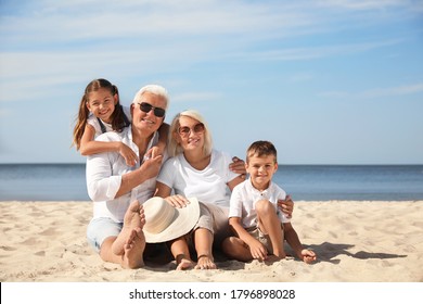 Cute little children with grandparents spending time together on sea beach - Powered by Shutterstock