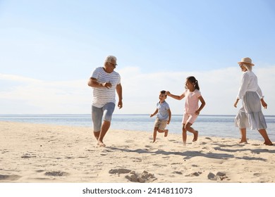 Cute little children with grandparents spending time together on sea beach - Powered by Shutterstock