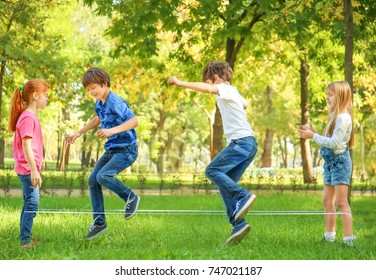 Cute little children jumping rope in park