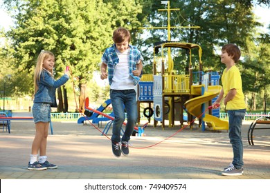 Cute little children jumping rope in park