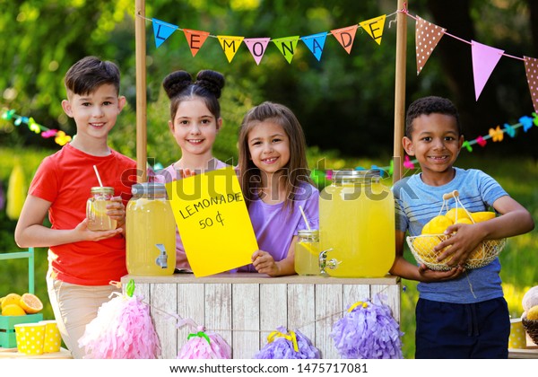 Cute little children at lemonade stand in\
park. Summer refreshing natural\
drink