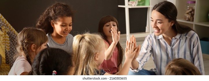 Cute little children with nursery teacher in kindergarten. Banner design - Shutterstock ID 2160303655