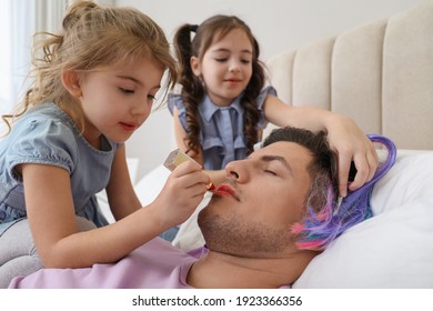 Cute Little Children Painting Face Of Their Father While He Sleeping In Bed At Home