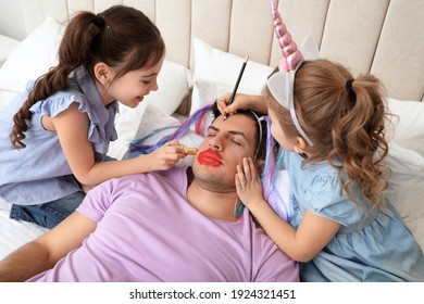 Cute Little Children Painting Face Of Their Father While He Sleeping In Bed At Home