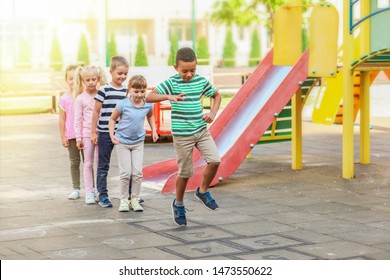 Cute Little Children Playing Hopscotch In Park