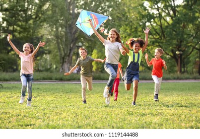 Cute little children playing with kite outdoors on sunny day