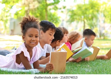 Cute little children reading books in park - Powered by Shutterstock