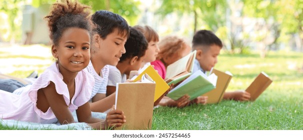 Cute little children reading books in park - Powered by Shutterstock