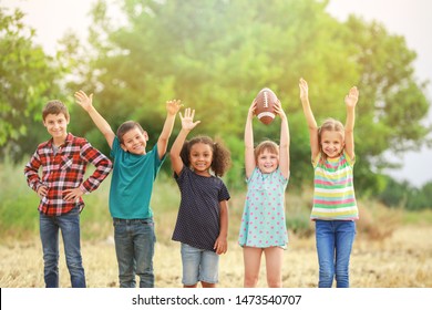 Cute little children with rugby ball outdoors