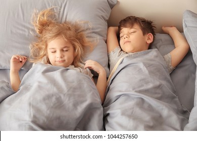 Cute little children sleeping in bed at home. Family bedtime - Powered by Shutterstock