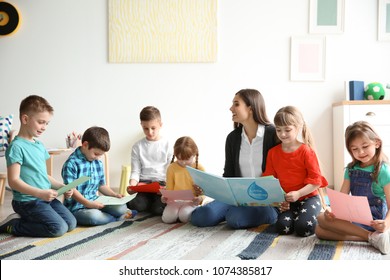 Cute Little Children With Teacher In Classroom At School