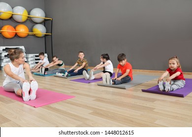 Cute little children and trainer doing physical exercise in school gym. Healthy lifestyle - Powered by Shutterstock