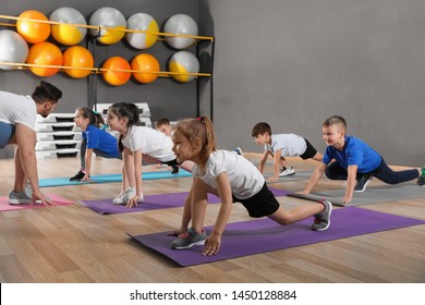 Cute little children and trainer doing physical exercise in school gym. Healthy lifestyle - Powered by Shutterstock