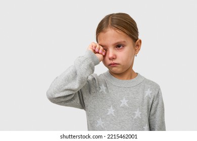 Cute little crying girl on white background with copy space. Portrait of a sad child girl with tear drops on eyes, close-up