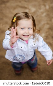 Cute Little Curly Hair Blonde Girl Waving And Smiling At Camera, Shot From Above