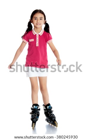 Cute little dark-haired girl in a pink tank top and white shorts on roller skates - Isolated on white background