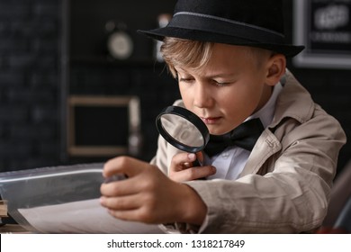 Cute Little Detective Working With Evidence At Table