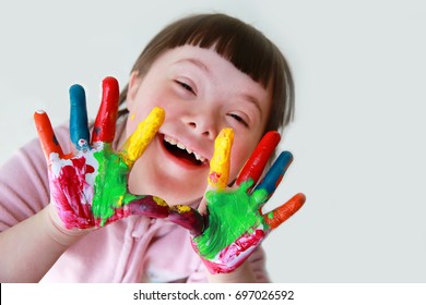 Cute little down syndrome girl with painted hands. - Shutterstock ID 697026592