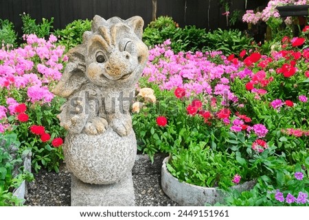 Cute little dragon with flowers, garden figurine to decorate the garden