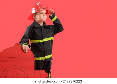 Cute little firefighter with paper hydrant on red background - Powered by Shutterstock