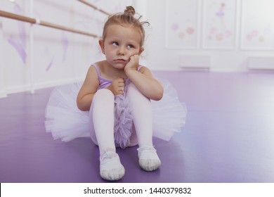 Cute little funny ballerina girl looking away with annoyed expression, copy space. Adorable little ballerina looking tired and bored at ballet class. Unhappy, angry child concept - Powered by Shutterstock