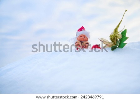 Cute little funny dwarf And a shiny twig in the snow in the landscape in winter. Wizard on a snowy background. Christmas and New Year
