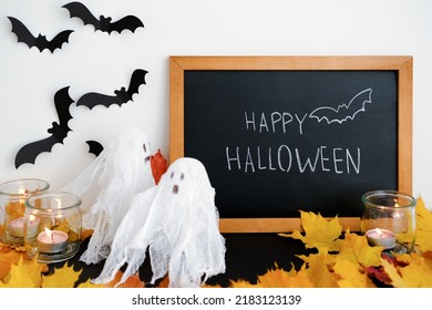 Cute little ghost the background the blackboard for the inscription Halloween