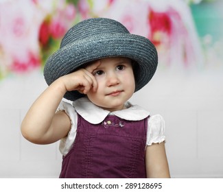 Cute Little Girl In Too Big Hat Looks Thoughtfully