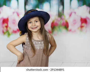 Cute Little Girl In Too Big Hat Posing Indoor With Copy Space